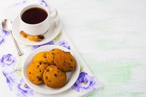 taza de té y galletas sobre fondo verde claro, espacio de copia foto