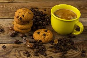 Yellow cup of strong coffee and cookies photo