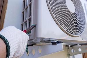 technician installing outdoor air conditioning unit photo