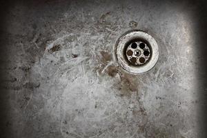 very old dirty sink with rusty metal drain closeup photo