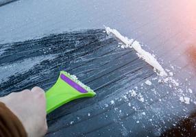 cleaning the glass machine from snow and ice brushing. photo