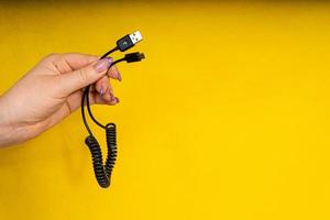 USB cable in hand close-up. Charging your phone photo