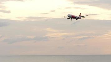 phuket, tailandia - 27 novembre 2019 compagnia aerea low cost airasia airbus a320 che scende per atterrare all'aeroporto di phuket, colpo lungo al tramonto. concetto di turismo e viaggio video