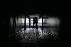 silhouettes of two lovers in a dark corridor photo