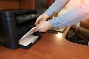 Human hand is reloading the paper to printer tray photo