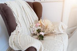 the bouquet is lying on a white blanket in a chair. photo