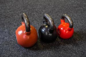 3 pesas yacen en el suelo del gimnasio. foto