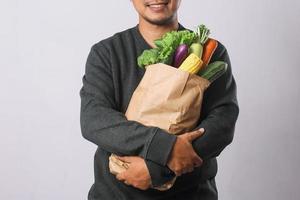 Man holding grocery shopping bag with vegetables for healthy lifestyle concept