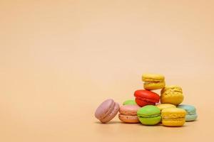 Stack of colorful macarons on cream colored background with copy space photo