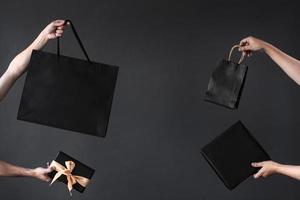 Crop of hand holding shopping bag or goodie bag for shopaholic or online shopping background photo