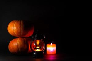 concepto de fondo oscuro de halloween con calabazas y linterna brillante foto