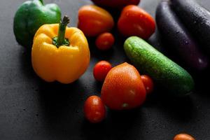 primer plano de coloridas verduras frescas sobre fondo negro foto