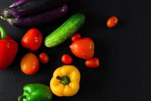 Top view of colorful fresh vegetables on black background photo