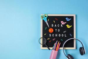 Flat lay of back to school concept on blue background with copy space photo