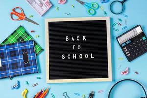 Flat lay of back to school concept on blue background photo