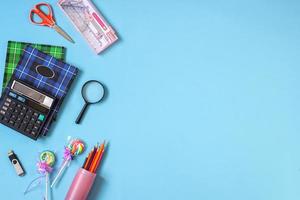 Creative flat lay school supplies on blue background for back to school concept photo