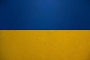 Ukraine flag background in blue and yellow from plaster wall texture pattern photo
