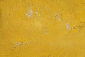 mustard yellow cement wall texture background has scratches and scuff marks.