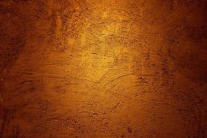 Golden brown plaster wall texture background with scratch and crack pattern photo