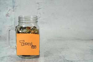 concept to save money for travel,notepaper on money box,glass bottle with coin photo