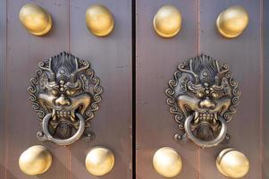 dragon head door knocker on a large wooden door photo