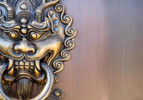 Metal dragon head door knocker in front of the entrance of Chinese temple, art related to religious beliefs photo
