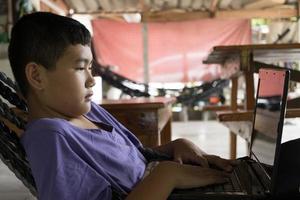 boy is studying online in a crib in a rural area. photo