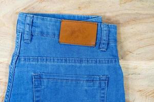 cuero brillante en blanco en la parte posterior de los jeans azules, etiqueta marrón en la cintura de los jeans para usar letras, fondos de mezclilla etiquetan ropa para la venta, etiquetas etiqueta de pantalones nuevos, foto