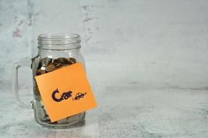 concept to save money for car,notepaper on money box,glass bottle with coin photo