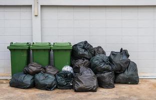 la basura en bolsas negras se coloca con contenedores de basura para separarlos en el sistema de gestión de residuos