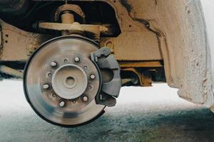 Disc brakes of old cars, vans with broken tires parked on the side of the road to change tires at a rural garage photo