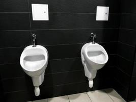 cierre la fila de bloques de inodoros urinarios en baños públicos tono de color azul limpio. foto