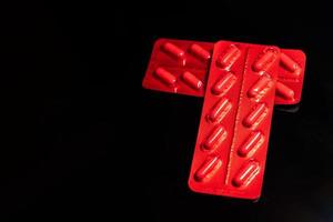 packages of tablets in a red wrapper on a black background. photo