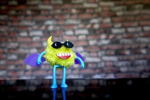 a coronavirus toy figure with glasses and wings on its back. photo