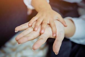 daughters hand in moms hand close up photo