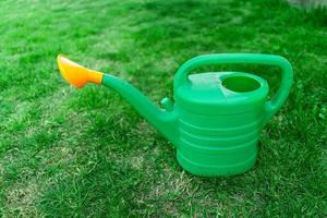 green watering can on the lawn photo