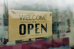 shop opening sign on glass door, photo