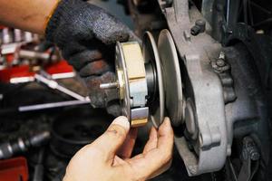 Mechanic working installing Clutch system on old scooter motorcycle at motorcycle garage. Clutch Replacement and repair and maintenance motorcycle concept.selective focus photo