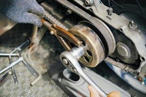 mechanic use special tools, Flywheel Clutch Hub Rotor Sprocket Spanner Wrench Tool and replace the clutch plates on scooter ,repair and maintenance motorcycle concept photo
