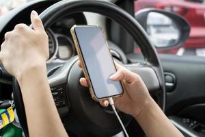 mujer conductora usando un teléfono inteligente en el auto. foto