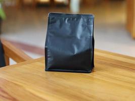 Photo of standing pouch coffee packaging on the cafe table. suitable for mock up label stickers, coffee variant packaging stickers or etc.