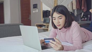 Young woman entering payment information form plastic card in  application, shopping in internet store, purchasing goods or paying for services online.