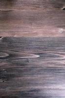 Background image of dark brown wood grain floor tiles.
