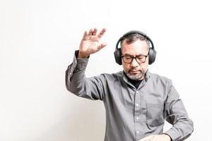 DJ dancing. Man wearing headphones playing music and dancing happily at a party. He had fun entertaining the honored guests. Selective focus the hand, copy space on left. White blurred background. photo