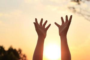 Woman hands praying for blessing from god on sunset background photo