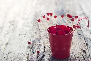 Valentines Day background with wood hearts in the red pot full of petal