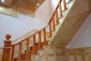 Beautiful wooden stairs. Golden stair made of wood, safety protection wooden stairs architecture interior design of contemporary, Modern house building stairway. photo