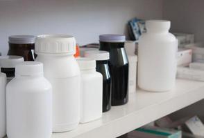 Bottles of pills arranged on shelf at drugstore photo