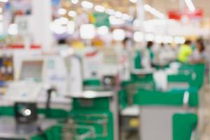 supermarket checkout payment terminal with customers blurred background photo