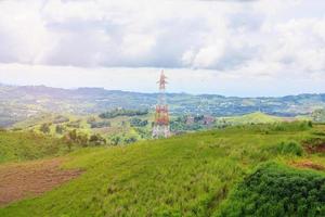 torre de líneas eléctricas de alto voltaje en montaña verde foto